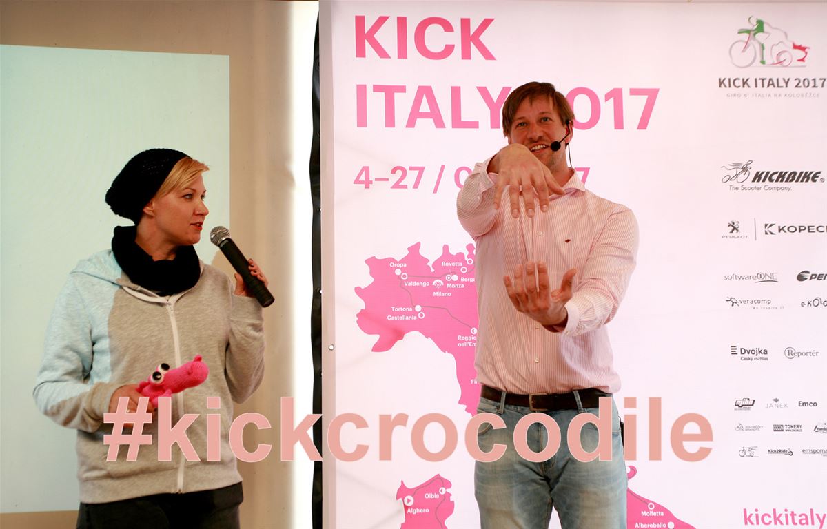 Václav Liška zeigt auf einer Pressekonferenz über das Giro auf Rollern die Krokodilsgeste.  