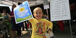 The happy winner of the running bike race is posing proudly for the photographs present.
