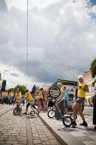 Průvod stávkujících míjí skupinu nadšenců na koloběžkách